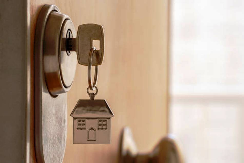 CLOSE UP OF KEY AND HOUSE KEYCHAIN ??IN HIGH SECURITY DOOR LOCK.